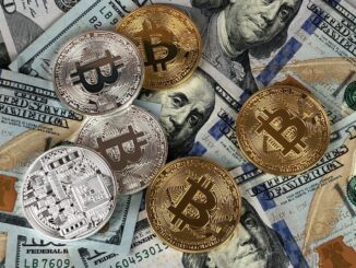 crypto coins dollar bills A mix of gold and silver Bitcoin tokens placed on top of US hundred-dollar bills